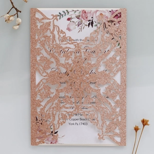 Macro detail of laser-cut rose gold glitter wedding invitation with floral insert card