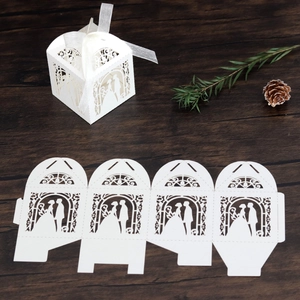 Laser-cut white wedding favor box with ribbon and bride silhouette on wood background