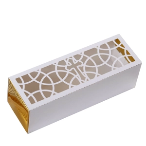 Detail of laser-cut cross and golden metallic foil on white religious gift box