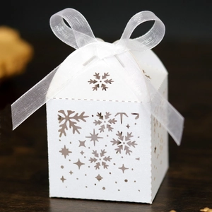 Détails de flocons de neige découpés au laser sur une boîte cadeau blanche avec ruban