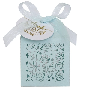 Macro view of light blue laser-cut rose gift box with organza ribbon and thank you tag