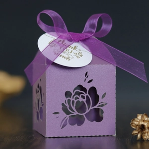 Macro shot of purple laser-cut gift box with floral patterns and a Thank You tag