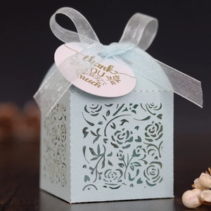 Detail of light blue laser-cut rose gift box with white ribbon and thank you tag