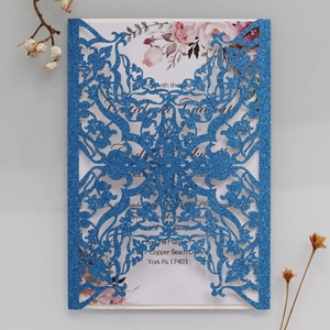 Detail showing laser-cut glitter blue wedding invitation with floral inner card