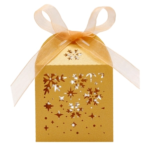 Détails de découpe laser en forme de flocon sur boîte à bonbons dorée de Noël