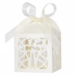 Detail of laser-cut cross pattern and ribbon bow on white hollow candy box for baptism