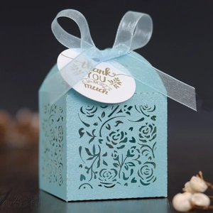 Detail of light blue laser-cut gift box featuring rose patterns and a thank you tag