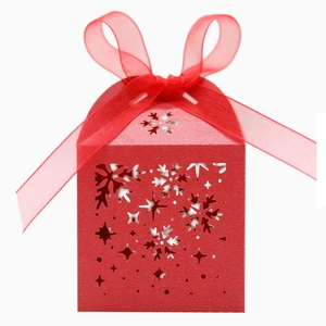Détail d'une boîte cadeau rouge découpée au laser avec flocon et ruban d'organza