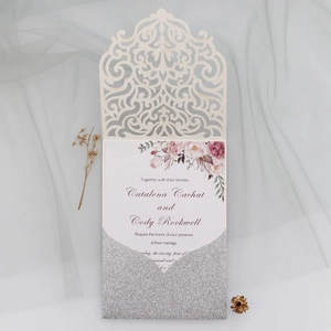 Détail de l'invitation de mariage découpée au laser avec motif floral rose et enveloppe pailletée