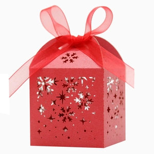 Détail de la boîte de Noël rouge avec flocons découpés au laser et nœud en satin