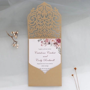 Detail der goldene Laser-Hochzeitseinladung mit elegantem Blumenmuster auf grauem Stoff