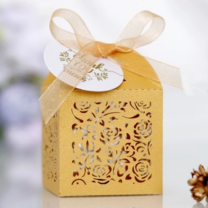 Detailed laser-cut gold gift box with rose patterns and champagne organza ribbon ties