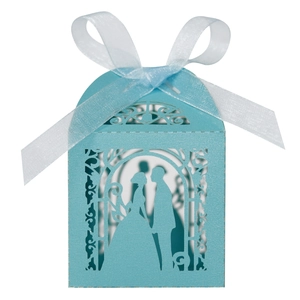 Close-up of light blue laser-cut wedding favor box with romantic silhouette and ribbon