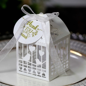 Laser-cut white wedding favor box with love birds, heart patterns and ribbon