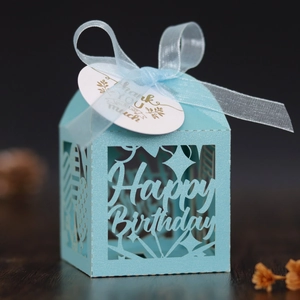 Macro view of light blue laser-cut candy box with Happy Birthday text and silk ribbon