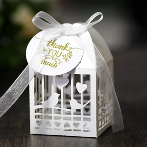White laser cut birdcage gift box with heart patterns and a thank you tag for weddings