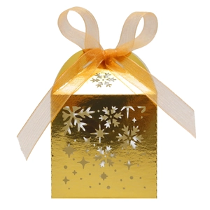 Gros plan sur la boîte cadeau dorée avec flocons ajourés et ruban d'organza orange