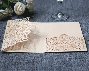 Detailed laser-cut mandala floral patterns on a champagne invitation pocket with roses