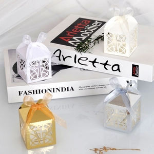 Close-up of laser-cut cross patterns on mirrored silver wedding favor candy gift boxes