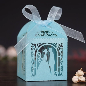 Detailed laser-cut bride and groom silhouette on blue favor box with organza ribbon