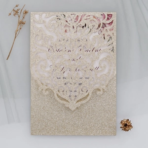 Détail d'invitation de mariage dorée pailletée avec découpe laser et motifs de vignes