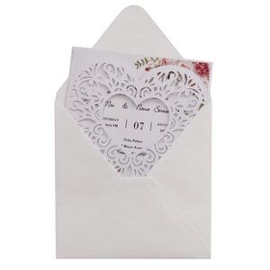 Detail of laser-cut heart wedding invitation with white envelope and floral inner card