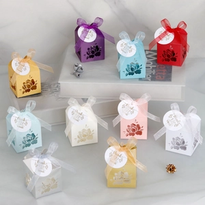 Macro detail of laser-cut rose patterns on colorful wedding favor boxes with ribbons