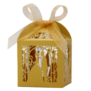 Detail of laser-cut gold wedding favor box with ribbon and bride and groom silhouette
