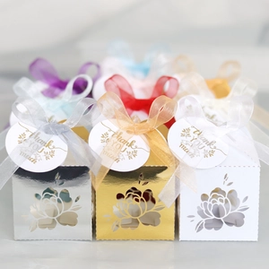 Detail of laser-cut floral wedding gift boxes with satin ribbons and thank you tags