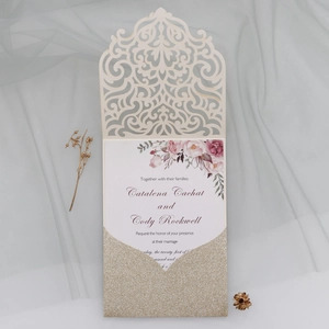 Détail de l'invitation de mariage découpée au laser avec motif floral et pochette dorée brillante