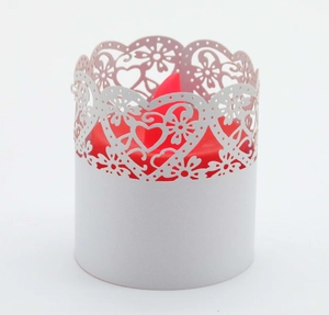 Detailed laser-cut white paper shade with heart patterns on a red LED candle lamp