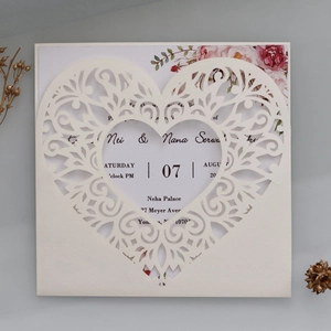Macro view of laser-cut cream pearl paper wedding invitation with floral insert