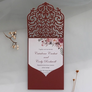 Nahaufnahme der lasergeschnittenen Hochzeitseinladung in Dunkelrot mit Blumenkarte