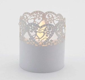 Detail of laser-cut heart pattern paper wrap with warm LED tea light candle inside