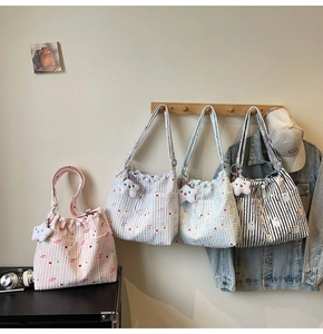 Détail de cabas en nylon matelassé avec fermeture à cordon et pendentif étoile