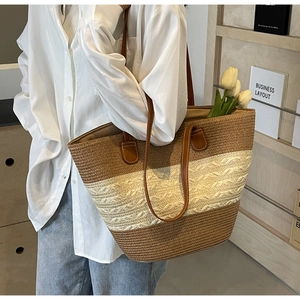 Close-up of contrast weave straw tote bag with brown leather straps and interior capacity