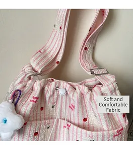 Détail du sac à cordon rayé rose avec imprimé Good Mood et pendentif en peluche