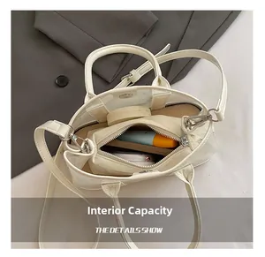 Vue macro du sac seau blanc crème montrant l'intérieur spacieux avec pochette zippée