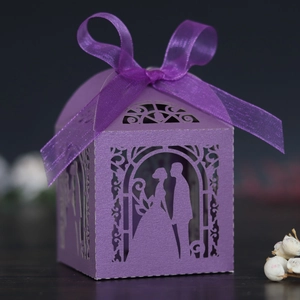 Detail of laser-cut purple gift box with romantic silhouettes and a silk ribbon