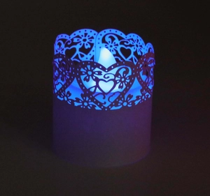 Macro shot of blue LED candle with intricate laser-cut heart and floral paper wrap
