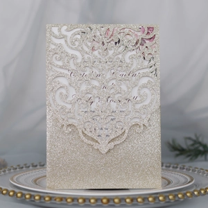 Détail d'invitation à paillettes or champagne découpée au laser sur une assiette