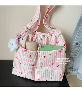 Vue détaillée du sac en nylon rayé rose avec motifs fraises et fermeture à cordon