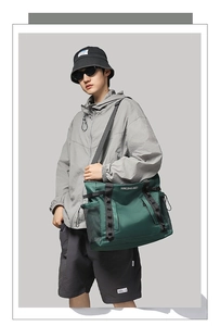 Detail of dark green waterproof travel bag showing durable nylon texture and side mesh pocket