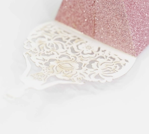 Detail of pink glitter candy box with white laser-cut floral lace decorative edge