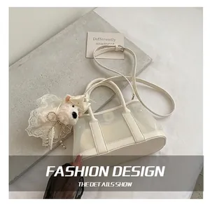 Détail du sac seau blanc translucide avec pendentif chiot peluche et bandoulière