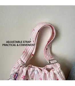 Détail de la boucle réglable et de la sangle en tissu à rayures et cerises