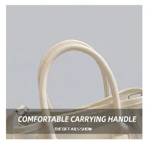Gros plan des doubles poignées du sac seau crème avec détails métalliques argentés sur veste