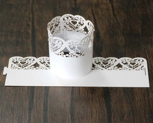 Close-up of laser-cut white heart and floral paper wrap for LED candles and parties