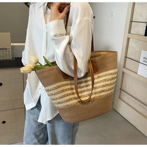 Detail of striped straw tote bag featuring leather straps and spacious interior