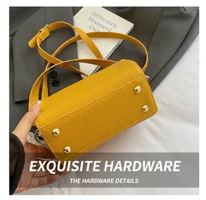 Detail showing high-quality golden metal rivets on the bottom of a yellow crossbody bag